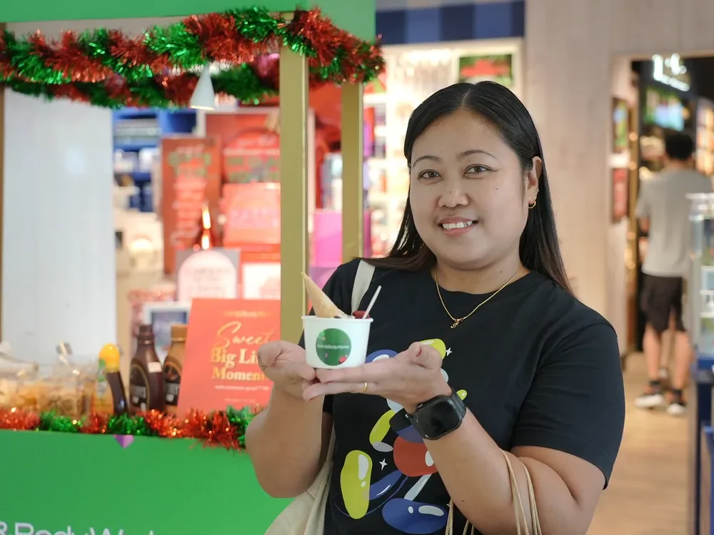 Guest presenting a branded dessert at the Bath & Body Works cart