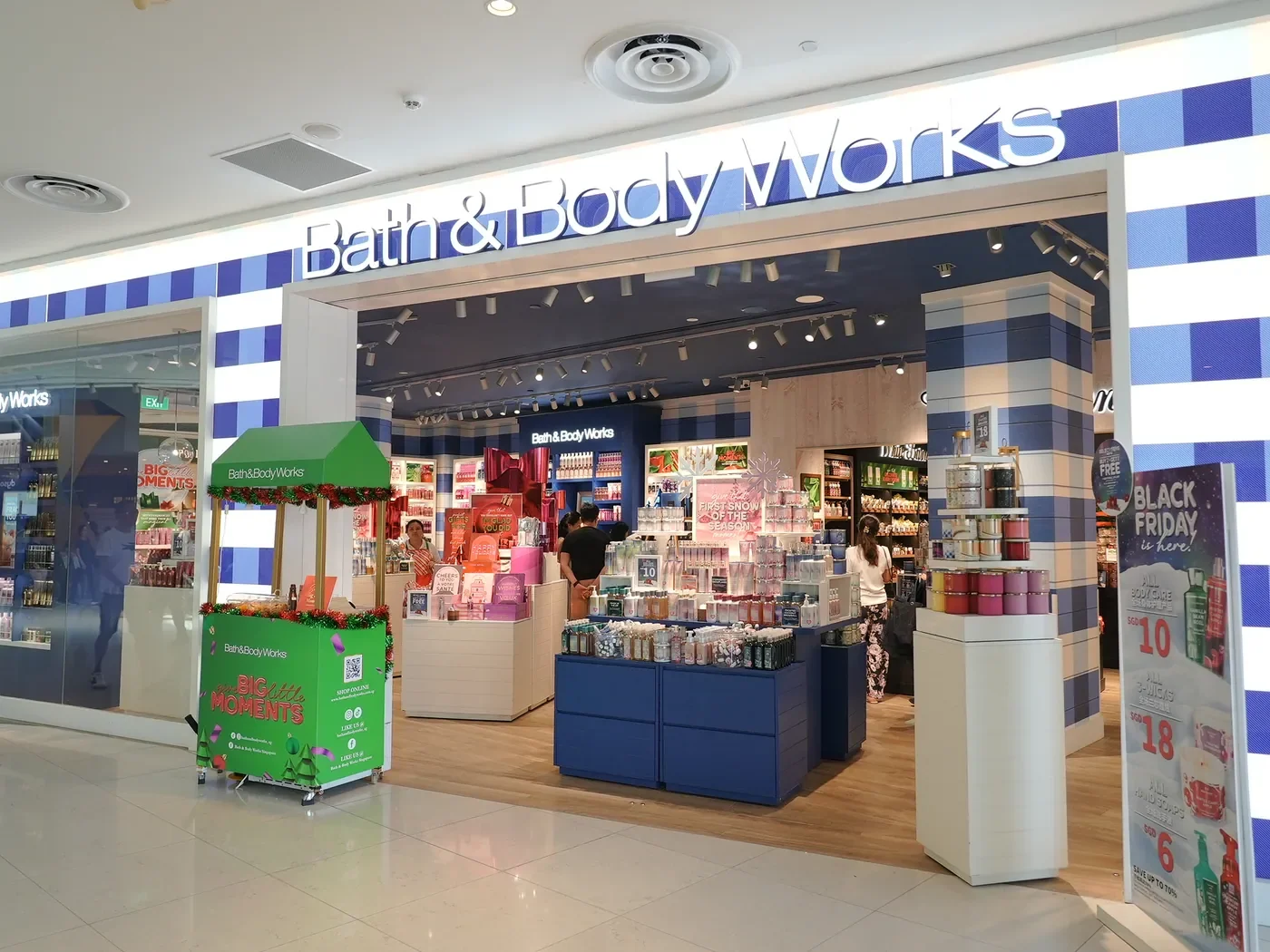 Bath & Body Works storefront with a green festive activation cart