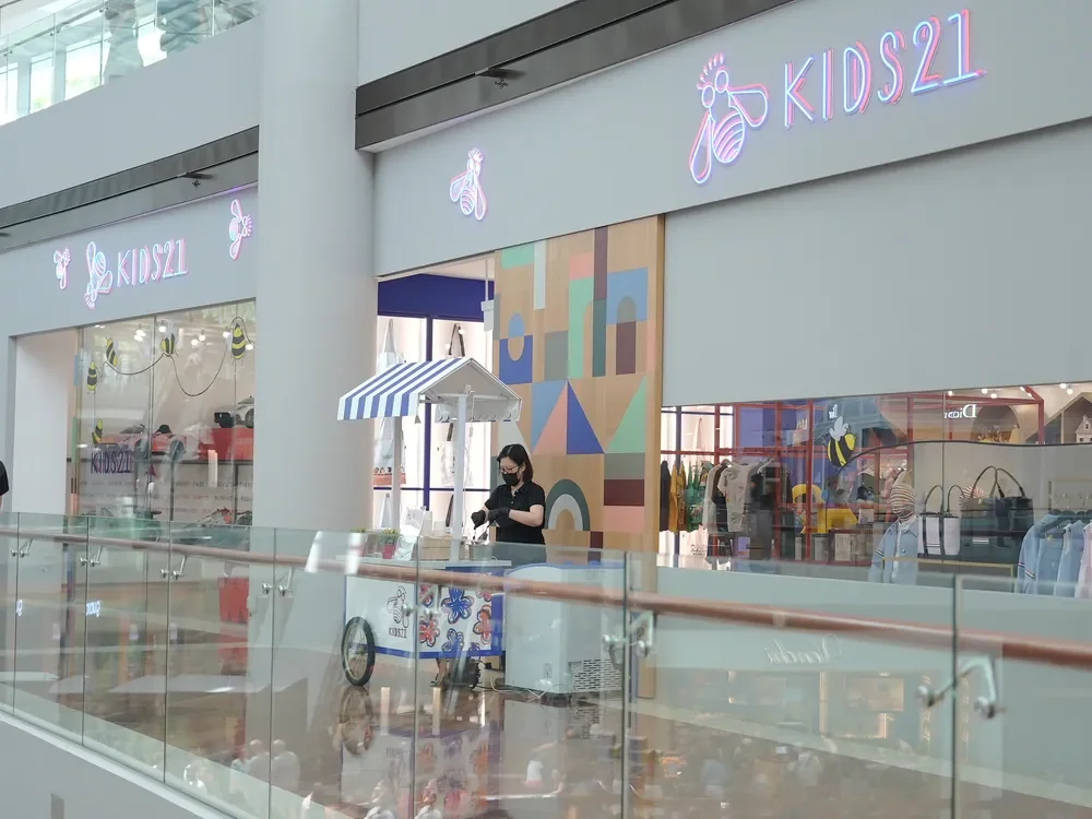Kids21 storefront with a blue-and-white activation cart